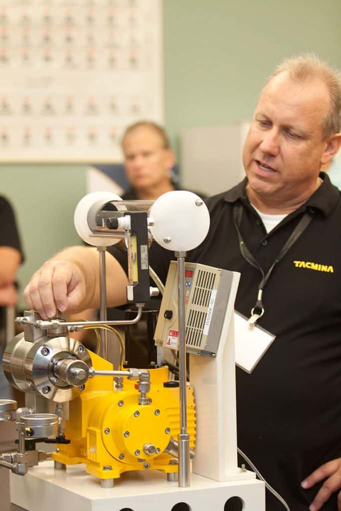 Tacmina Staff Demonstrating A Smoothflow Pump At A Technical Conference